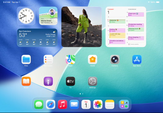 Tre iPad-modeller vises i liggende retning. Modellen i midten overlapper delvis de to andre. Apple Pencil er festet magnetisk til toppen av modellen i midten, og denne enheten viser fargerike appsymboler med Liquid Glass-effekt på Hjem-skjermen. Modellen til venstre viser Forhåndsvisning-appen på skjermen, mens Hjem-skjermen på modellen til høyre viser Dock med apper spredt ut i en vifteform.