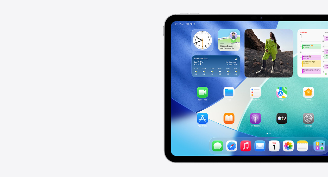 Kun venstre side av skjermen vises på en iPad i liggende retning. Hjem-skjermen viser stablede widgeter og en gjennomskinnelig klokke med Liquid Glass-effekt, Hvor er-appen, Været-widgeten, to rader med mindre appsymboler og Dock.