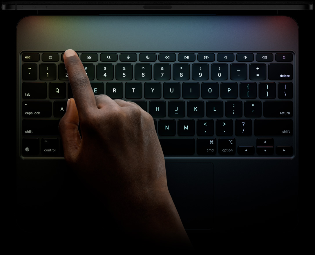 جهاز iPad Pro، الوضع الأفقي، لون أسود فلكي، صورة الحافة العلوية، مثبت على لوحة مفاتيح ماجيك، الجزء الأمامي الخارجي، الوضع الأفقي، مفاتيح سوداء بإضاءة خلفية، صف مفاتيح وظائف مخصص، مفاتيح Escape، ‏Tab، ‏Caps Lock، ‏Shift، ‏Control، ‏Option، ‏Shift، ‏Delete، ‏Return، مفاتيح للأسهم مرتبة على شكل حرف 